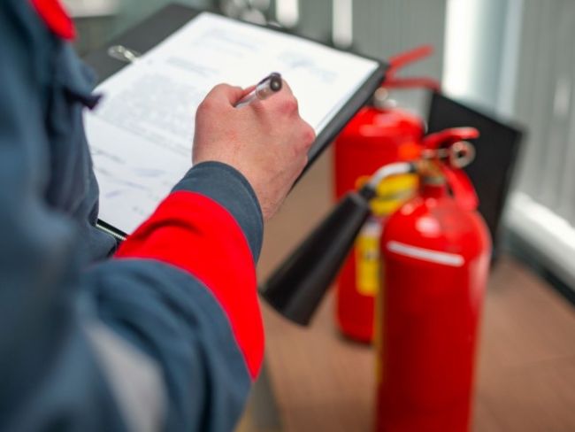 hand and clipboard with fire extinguishers