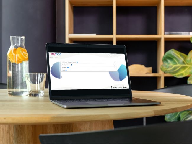 laptop on a desk with jug of water