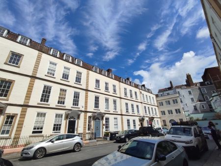 terraced houses with cars and blue sky